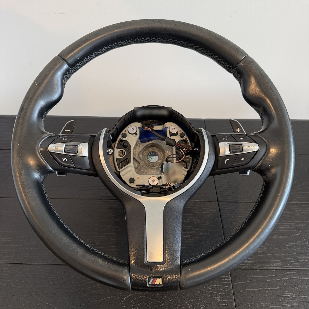 Worn BMW M Sport steering wheel with faded, greyish leather before restoration