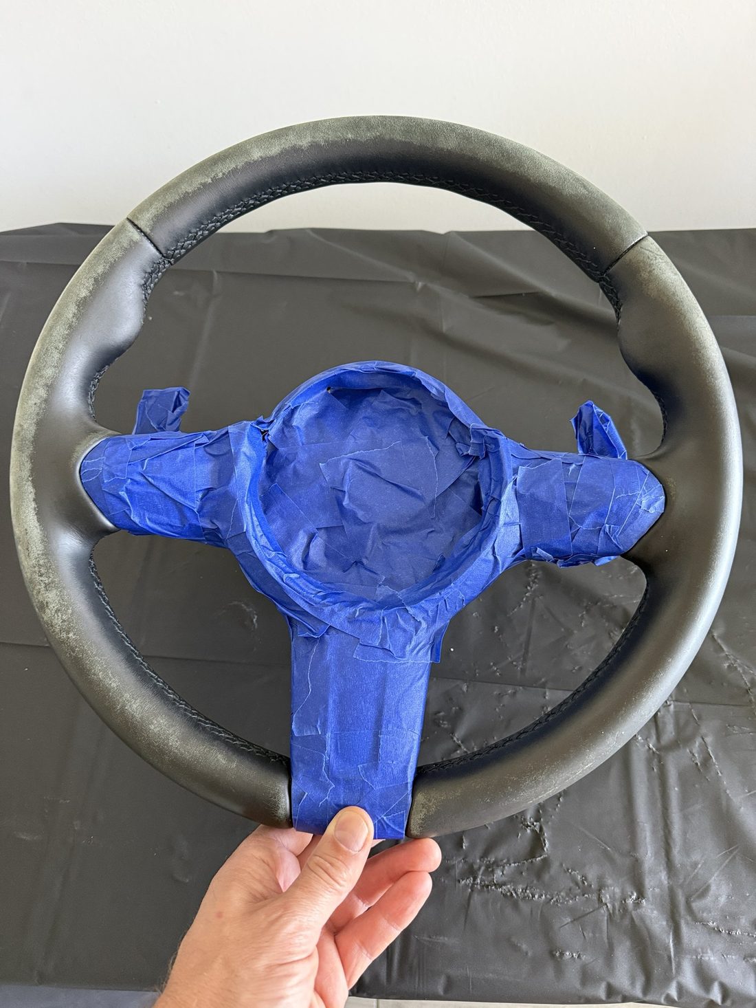 Steering wheel rim with the old finish sanded back to bare leather